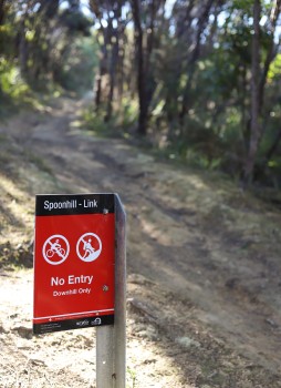"No entry downhill only" sign on a trail