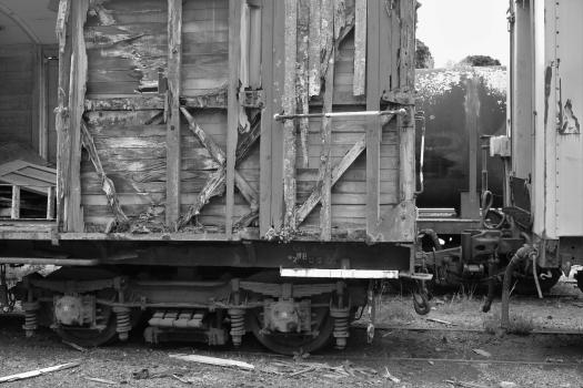 Damaged old wooden freight bogie and tanker monochrome