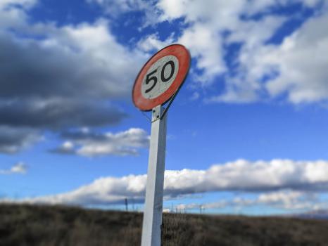 50 speed limit sign against cloudy blue sky