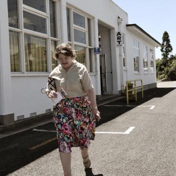 Woman floral skirt walking art gallery in Tairua