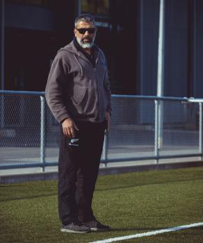 Guy with a beard and sunglasses spectate from sidelines - Sports Zone sunday league