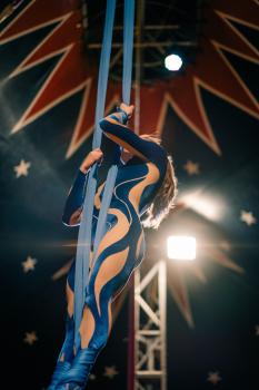 Female acrobat performing in blue attire at circus