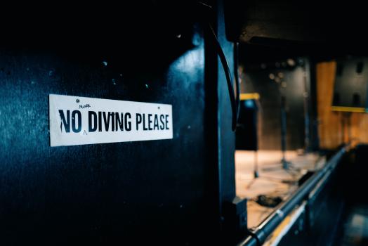No stage diving sign on a black wall