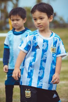 Little football player standing in front of second boy bokeh - Little Dribblers