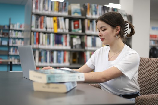 Young lady working on laptop in library