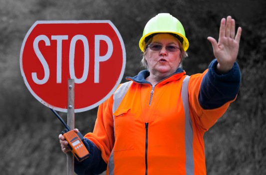 Lady with colourful red stop warning sign