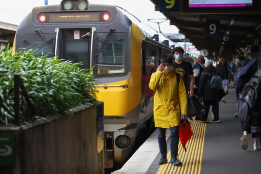 Guy in yellow raincoat on a train platform