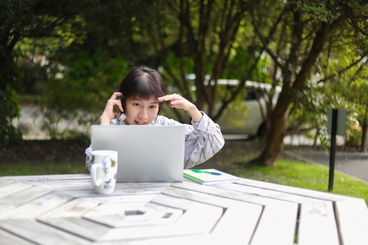 Young Asian-looking lady working outside