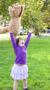 Child with Down syndrome raising arms