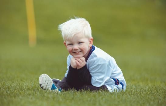 White haired boy posing for a photo at Little Dribblers soccer bout