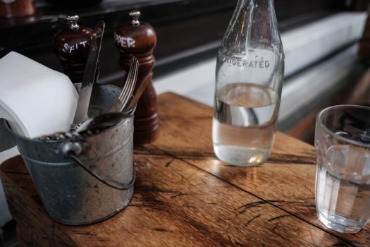 Cutlery salt and pepper container bottle and glass at a cafe
