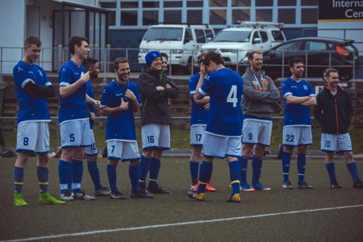 Football teammates in blue shirts stand in a line - Sports Zone sunday league