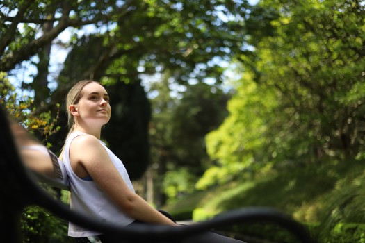 Woman sitting on a bench in greenery