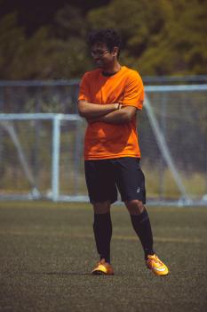 Football player in orange shirt and orange Nike cleats - Sports Zone sunday league