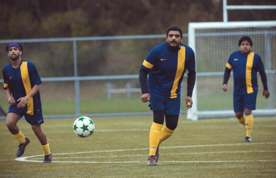 Player in blue and yellow Nike kit passes the ball - Sports Zone sunday league