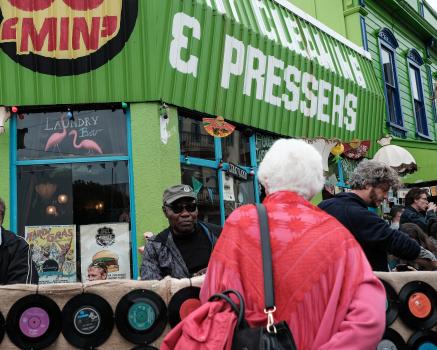 Old woman wearing a pink coat looking at vinyls