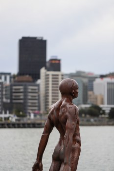 Rusted statue of a naked man on the wharf