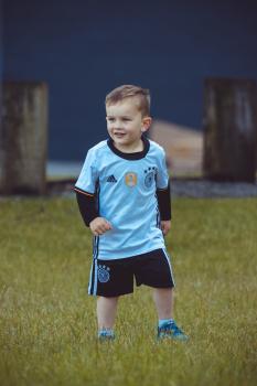 Little boy wearing blue jersey and black shorts - Little Dribblers