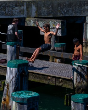 Boys jumping off the wharf
