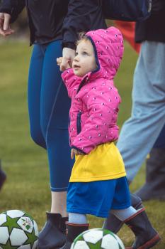 Little girl in pink hoodie and high boots at Little Dribblers soccer play-off