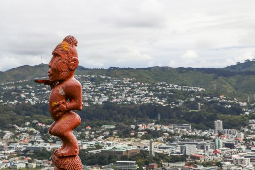 Māori sculpture and urban backdrop