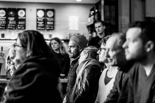 Audience enthralled by a performance at a bar black and white