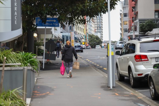 Woman carrying bags walking on pavement
