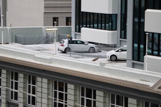Two white cars parked on rooftop