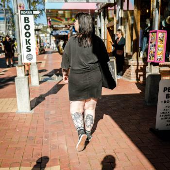 Woman in black walks down street