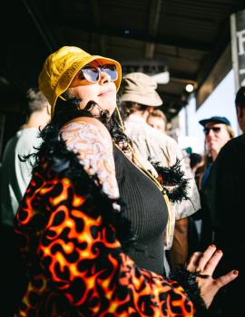Tattooed woman dancing in a flame textured coat at Newtown festival 2021