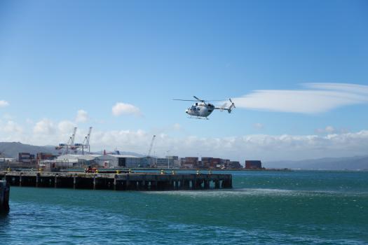 White helicopter landing on the harbour