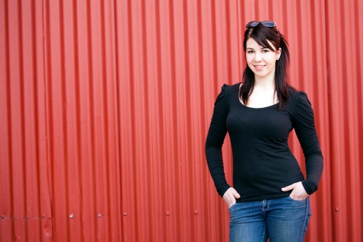 Pretty woman in blue jeans with red wall