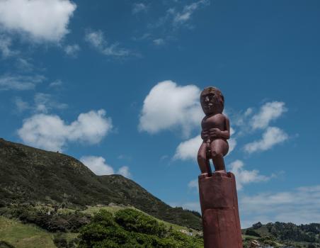 Maori Carving statue (Powhenua) hills in the back