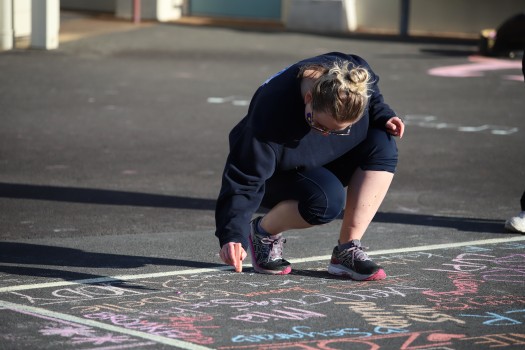 Lady drawing with chalk on tarmac, R4L 2022