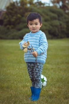 Boy with a tree branch and blue little rain boots - Little Dribblers