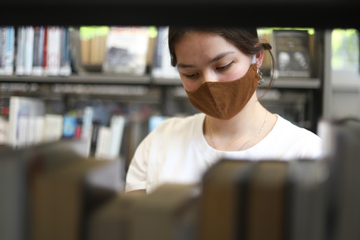 Brown mask donning girl in library
