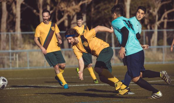 Football player with blue Nike headband dashing after football - Sports Zone sunday league