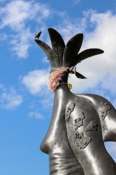 Little metallic bird on top of statue
