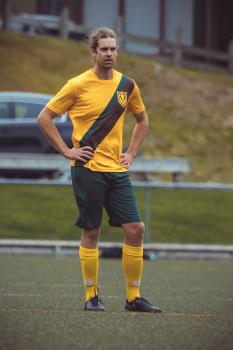 Football player in yellow shirt and green shorts portrait - Sports Zone sunday league