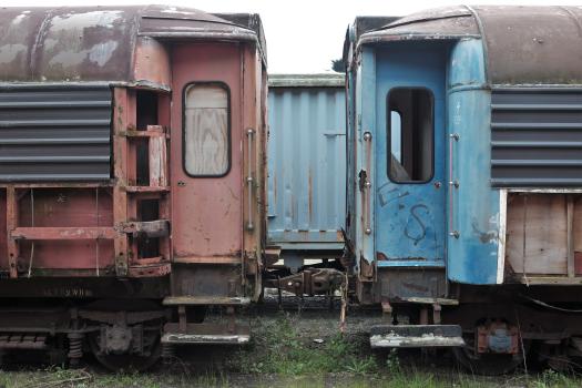 Abandoned old red and blue passenger bogies