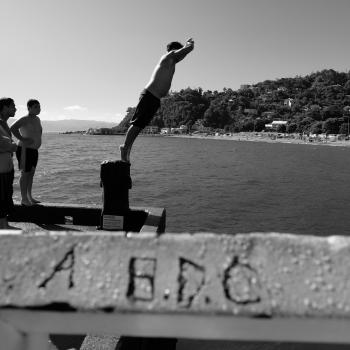  Boy diving from a platform on wharf into the water in Days bay monochrome