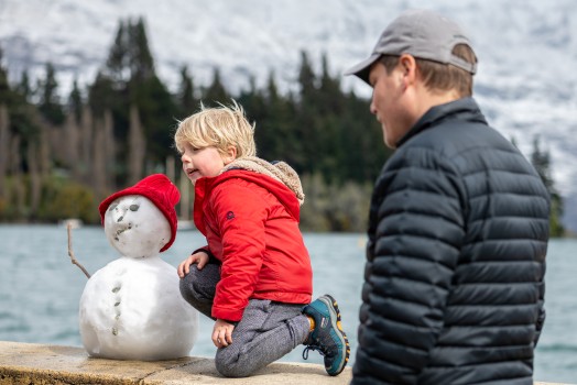 Boy and snowman in red