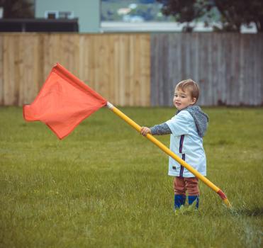 Boy grabbing yellow pole with red flag - Little Dribblers
