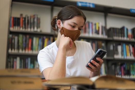Girl wearing mask reading from her phone