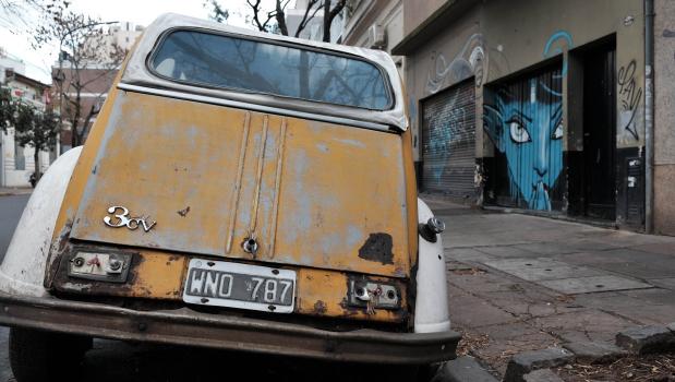 A damaged classic Citroen 3cv parked in the street