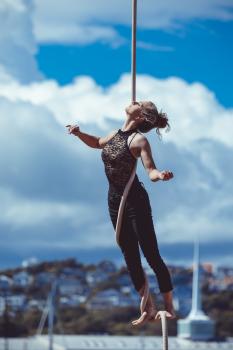 Woman acrobat hanging from a rope