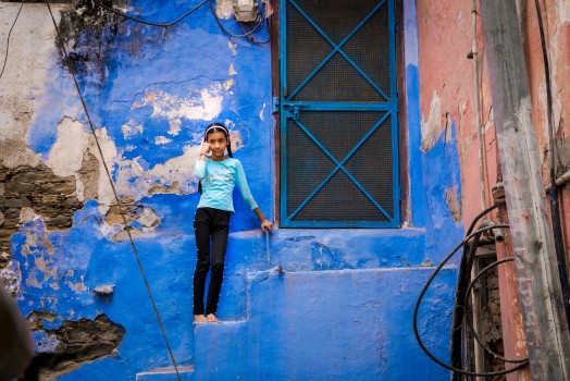 Little girl standing on blue steps, India