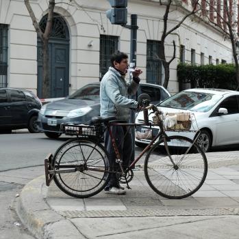 Man with bicycle in the street playing harmonica