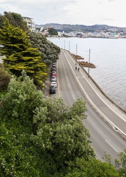 Cyclists and parked cars on coastal road
