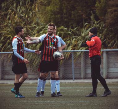 Player holding football talking to referee - Sports Zone sunday league